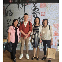 這張照片呈現一場具文化與藝術交流意義的參訪活動，背景可見「國立故宮博物院 × 胡焱榮翡翠風華」的視覺元素，顯示此次場域具有高度文化與藝術價值，結合傳統書法與翡翠藝術的展示氛圍，整體定位偏向高端文化與收藏市場。